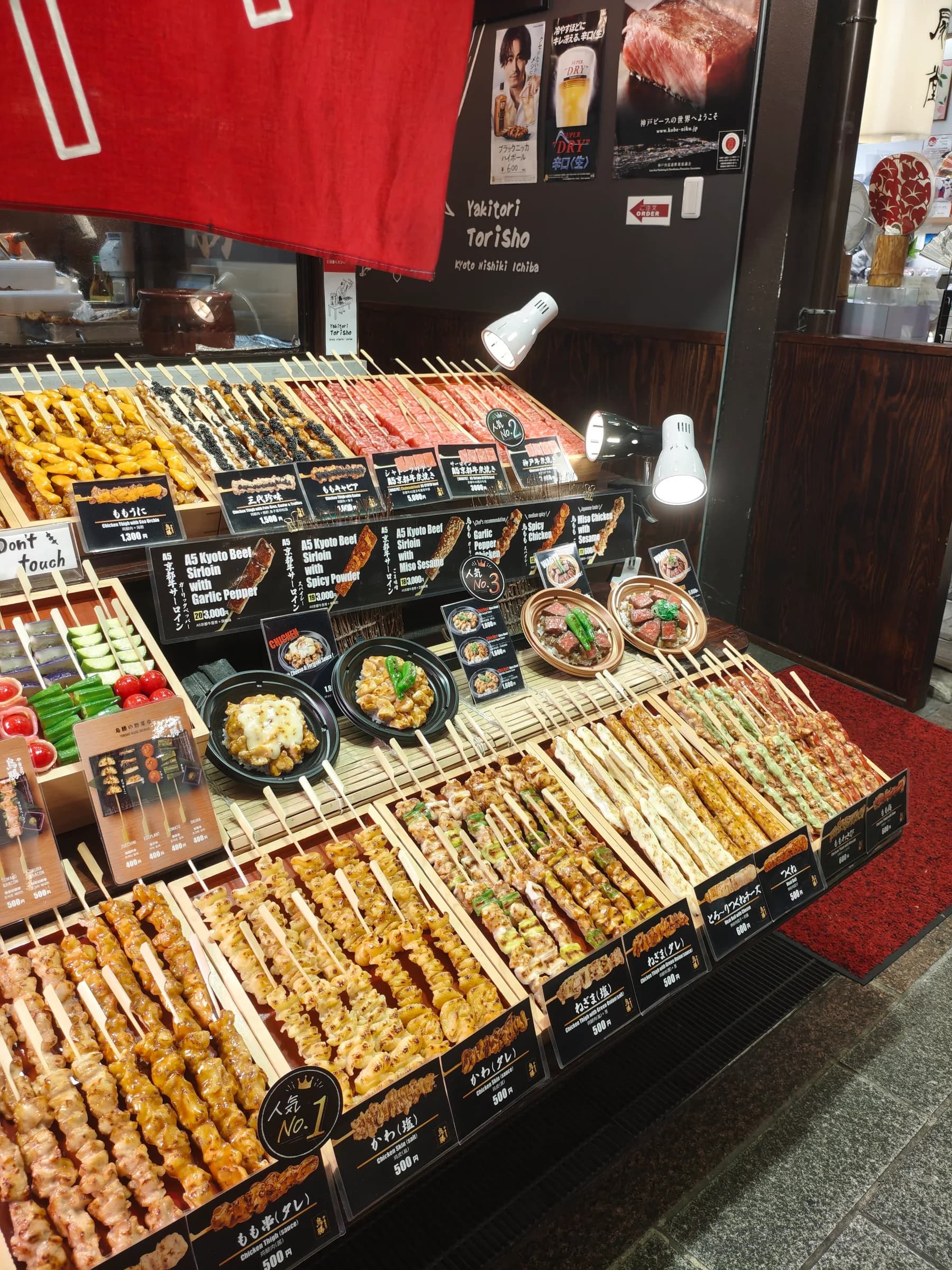 A food stall displaying various skewers in Nishiki market
